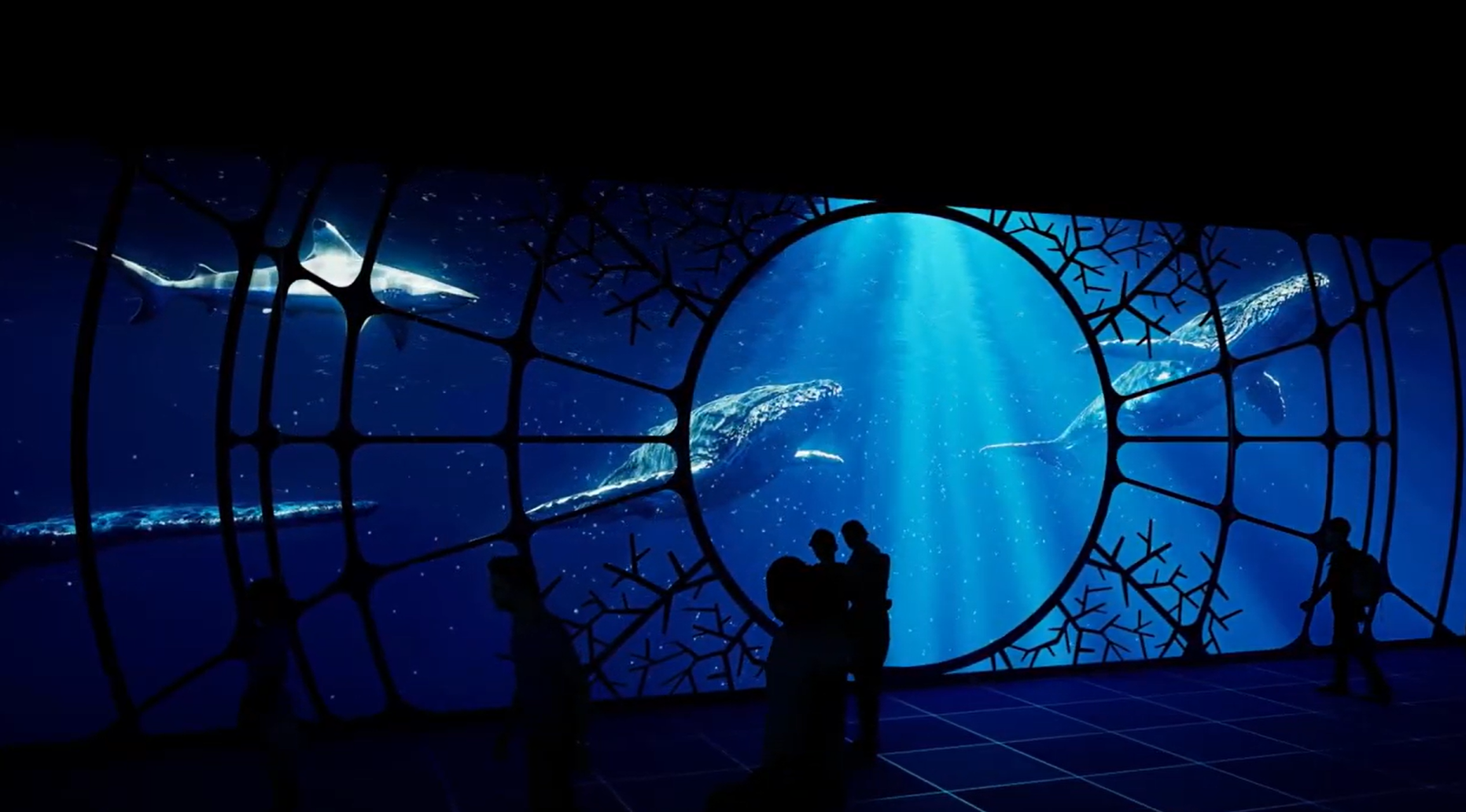 A full-scale wall LED screen with images of a pod of whales.